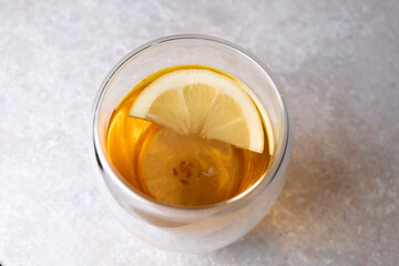 Tea with lemon in a glass cup on a stone table