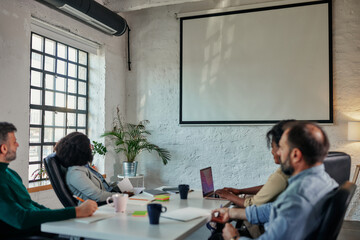 Businesswoman giving a presentation to coworkers in a boardroom meeting