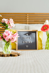 Welcome spring sign with vintage chalkboard on a white bed 