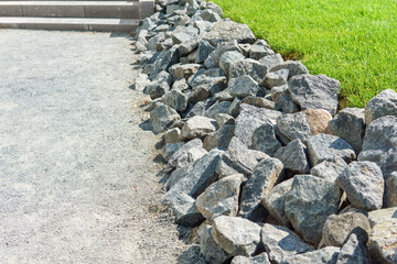 The lawn area and walkway are bordered by stones. A modern courtyard.