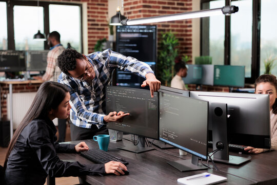 Cyber security agency coworker indicating on screen high usage of processing power on data grid information. Tech engineers detecting cloud leak and solve it with improved application coding. - Powered by Adobe