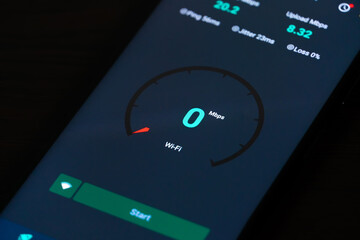 Close-up of a mobile phone with internet speed check on a black background