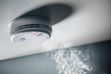 Smoke detector and interlinked fire alarm in action background - 492550716