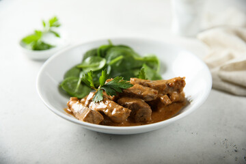 Homemade beef ragout with fresh spinach