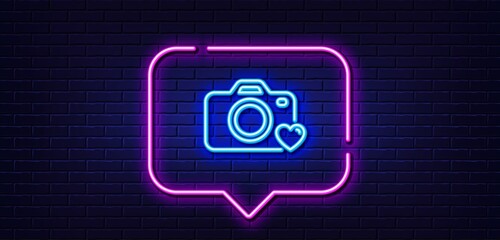 Neon light speech bubble. Photo camera line icon. Love photography sign. Heart symbol. Neon light background. Photo camera glow line. Brick wall banner. Vector © blankstock