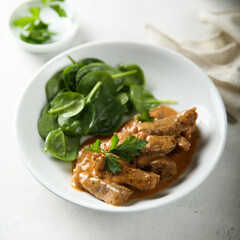 Homemade beef ragout with fresh spinach