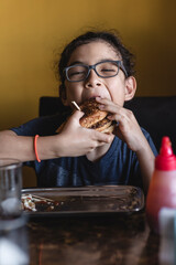 Vertical of a child eating a delicious hamburger