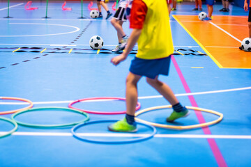 Indoor Soccer Class for Kids at School Sports Hall. Children Kicking Soccer Balls on Wooden Futsal...
