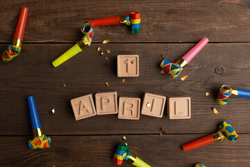 date April 1. Creative concept for April Fools' Day. Wooden letters April 1st and festive decor on the wooden background