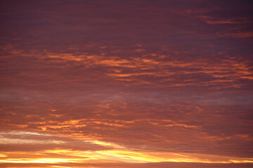 Bright colorful sunset sky with rays of setting sun and vivid dark clouds