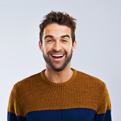 Just laugh. Studio shot of a happy and handsome man laughing against a gray background.