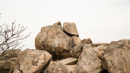 Climbing rocks, pine trees, scenery, and mountain silhouettes far away on a day with severe fine dust.