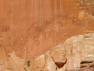 Fototapeta na wymiar Petroglyphs, also called Rock Art, can be seen by any passer by carved in the red sandstone bluffs on the road bordering the Green River to the west of Moab, Utah.