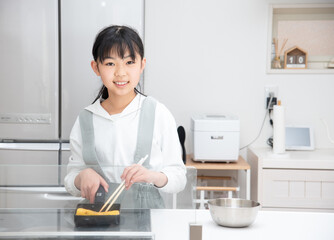 卵焼きを作る小学生の女の子