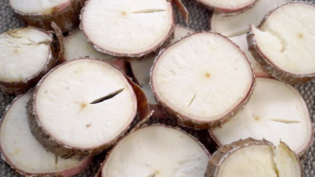 Sliced yucca root. Raw manioc slices. Dried cassava plant. Macro. Rotation
