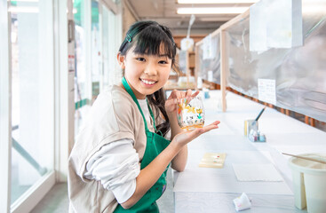 ガラス体験工房で絵付け体験をするアジア人の女の子