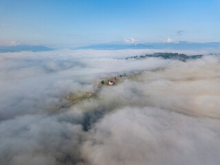 High flight above the clouds in the mountains. Aerial drone view.