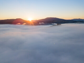 Sunrise over the fog in the Ukrainian Carpathians. Aerial drone view.