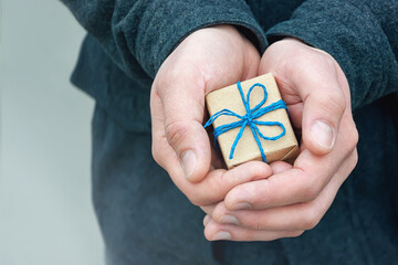 A small gift in a man's hands, selective focus.