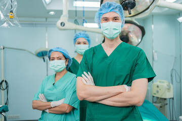 Portrait of Asian men surgeon and nurse with medical mask standing with arms crossed in operation...