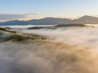 Mountain settlement in the Ukrainian Carpathians in the morning mist. Aerial drone view.