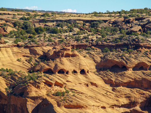 Holes in Cliff. The Canyon de Chelly is located in northeastern Arizona, it is within the boundaries of the Navajo Nation and lies in the Four Corners region
