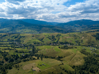 Green mountains of Ukrainian Carpathians in summer. Coniferous trees on the slopes. Aerial drone view.