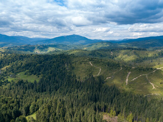 Green mountains of Ukrainian Carpathians in summer. Coniferous trees on the slopes. Aerial drone view.