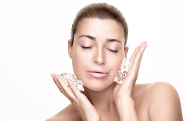Spa Woman with healthy clean skin applying ice cubes on face. Cold Beauty Treatments. Beauty face