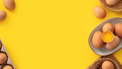 Fresh brown chicken eggs isolated on yellow table background.