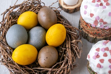 Easter cake and painted colorful eggs on light gray background.