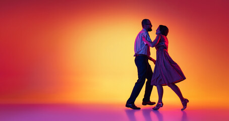 Portrait of excited man and woman, couple of dancers in vintage retro style outfits dancing lindy hop dance isolated on gradient yellow and purple background. Flyer