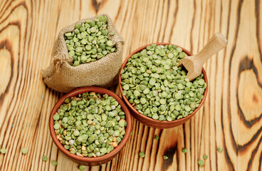 Green pea groats in bowls and bags on a wooden background. High quality photo
