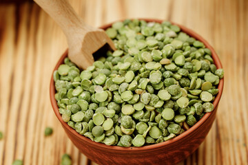 Green pea groats in bowls and bags on a wooden background. High quality photo