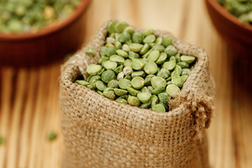 Green pea groats in bowls and bags on a wooden background. High quality photo