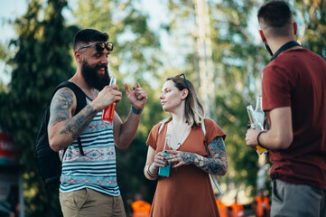 Obraz premium Group of friends drinking cocktails and having fun at music festival
