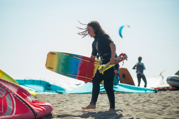 Woman holding kiteboard, flying lines and a control bar