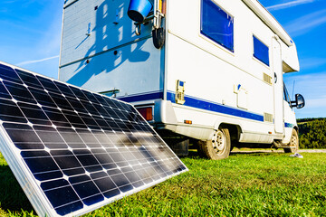 Camper with portable solar panel on coast