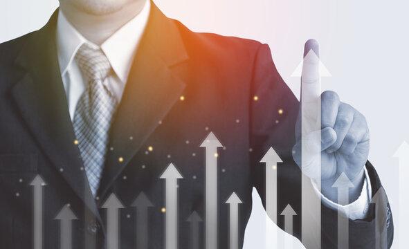 Multi exposure of businessman's hand touch the arrow line on the graph chart of stock market,.investment, forex graph ,earning.profit ,economic trend for investment guideline.