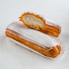 Traditional french eclairs filled with vanilla cream and powdered sugar.
