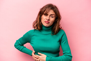 Fototapeta premium Young caucasian woman isolated on pink background having a liver pain, stomach ache.