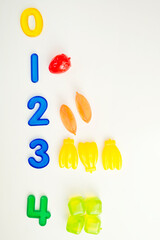 Numbers and toys. Artificial fruits and digits. Idea for children learning to count. Montessori concept, early education.