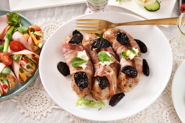 Easter grilled white sausage wrapped in bacon with prune and horseradish