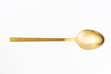 close-up of gold spoon on white background
