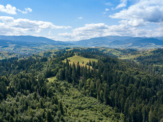 Green mountains of Ukrainian Carpathians in summer. Coniferous trees on the slopes. Aerial drone view.
