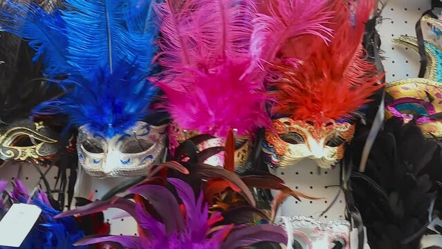 Panning sideways close up view of Venetian Carnival colorful masks, Venice in Italy. Slow motion