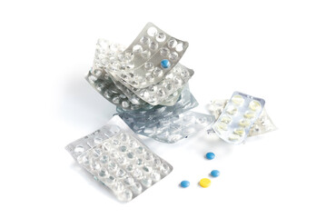 Empty blisters from medicines lie next to colored pills.
