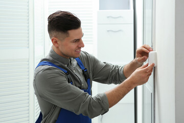 Professional electrician repairing light switch in room