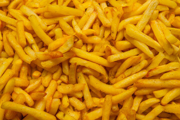 Fried potatoes close-up. Background of french fries with food tongs.