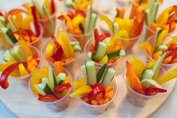 Beautifully decorated catering banquet table with variety of colorful vegetables and different vegan vegetarian snacks appetizers setting on corporate birthday party event or wedding celebration